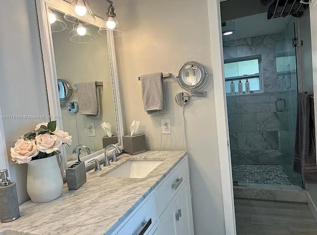 bathroom featuring vanity and a shower with door