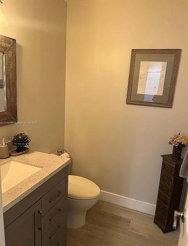 bathroom with vanity, toilet, and wood-type flooring