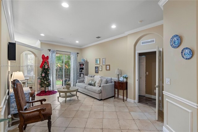 tiled living room featuring ceiling fan with notable chandelier and crown molding