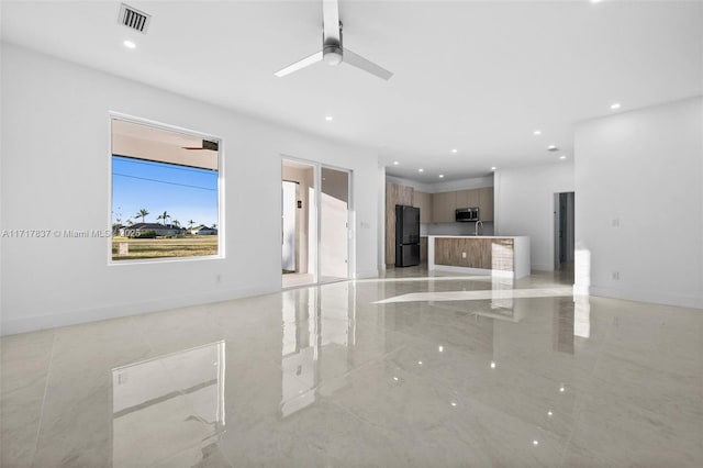 unfurnished living room featuring ceiling fan