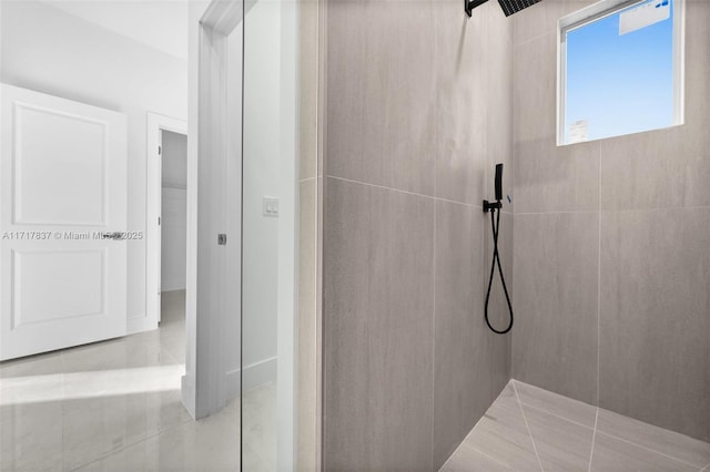 bathroom with tile patterned flooring and tiled shower