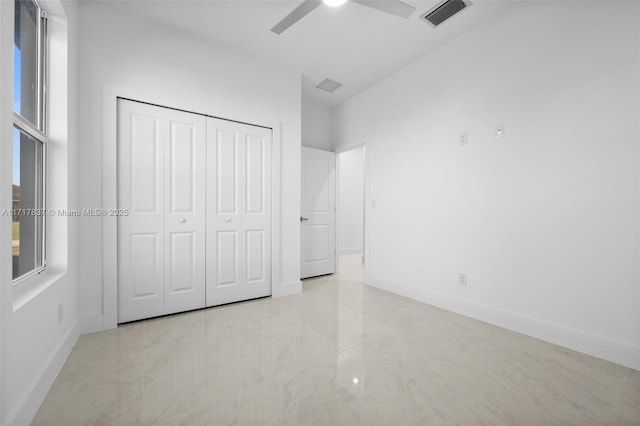 unfurnished bedroom with ceiling fan and a closet