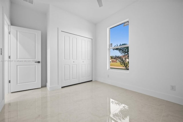 unfurnished bedroom featuring ceiling fan and a closet