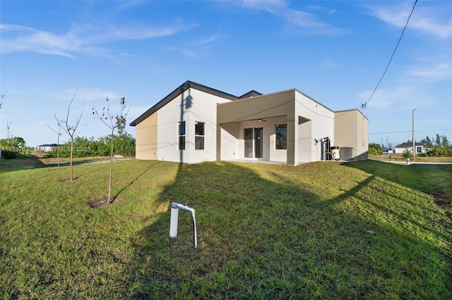 back of property featuring a lawn and central AC unit