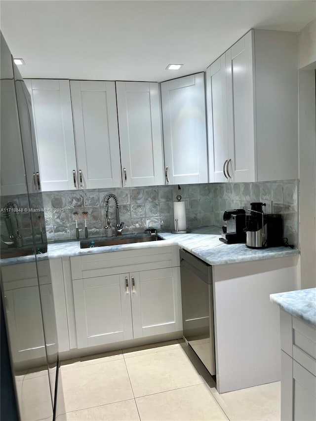 kitchen featuring dishwasher, backsplash, sink, and light tile patterned flooring