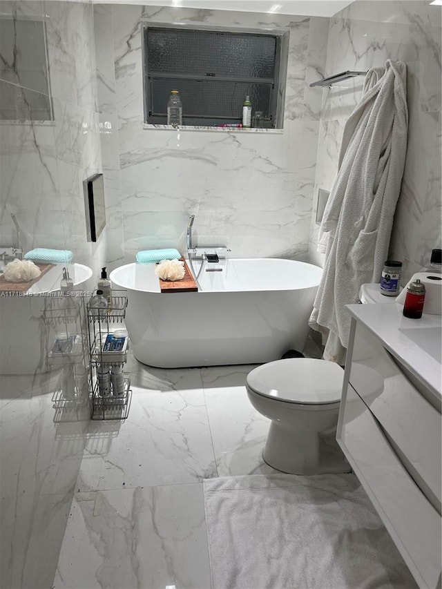 bathroom featuring vanity, toilet, and a tub