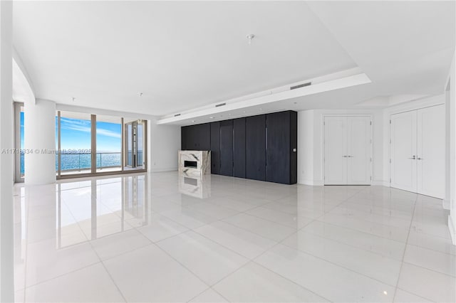 tiled empty room with floor to ceiling windows and a water view