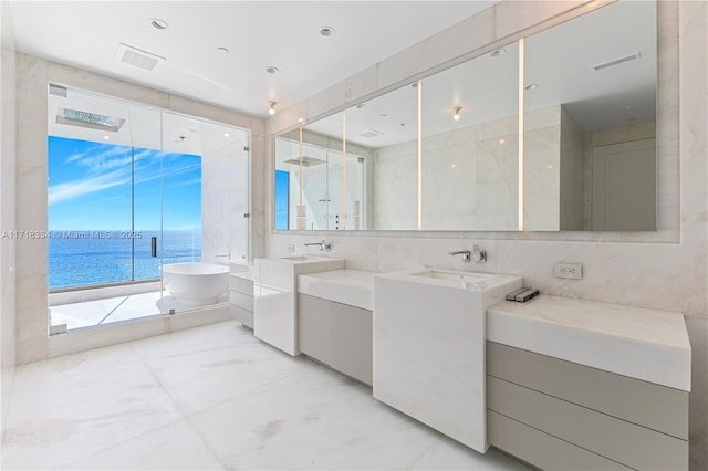 bathroom featuring vanity, a water view, tile walls, and plus walk in shower