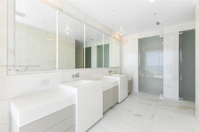 bathroom with a shower, vanity, tile walls, and washer / dryer