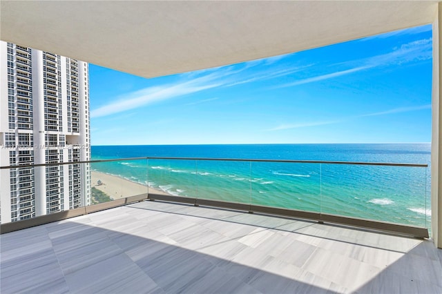 balcony featuring a water view and a beach view