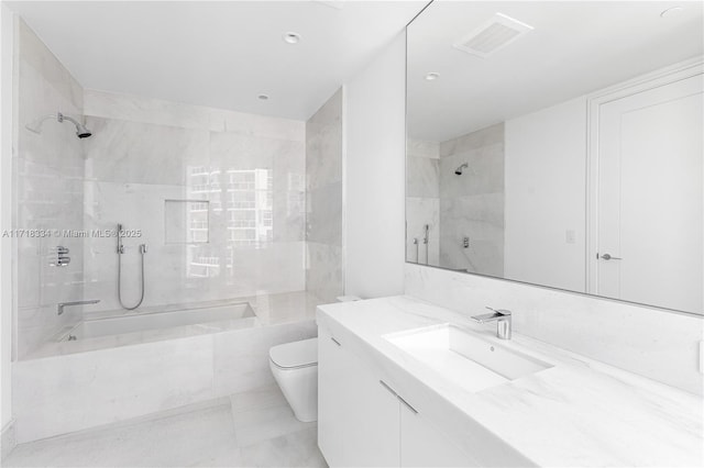 full bathroom with vanity, toilet, and tiled shower / bath