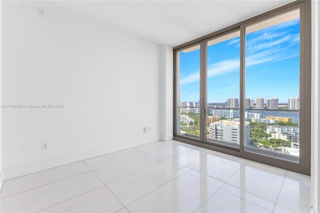 tiled spare room featuring a wealth of natural light and expansive windows