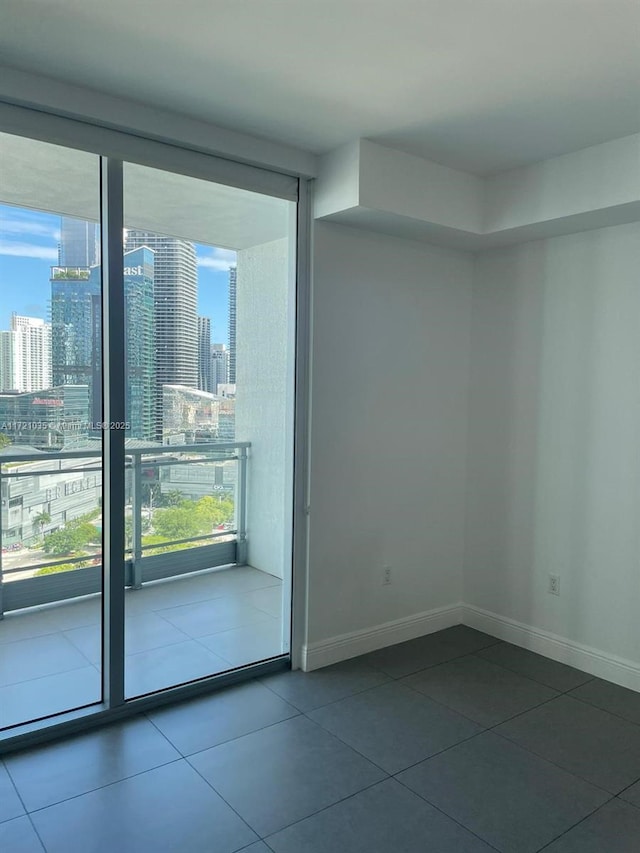 spare room featuring tile patterned flooring, expansive windows, and a wealth of natural light