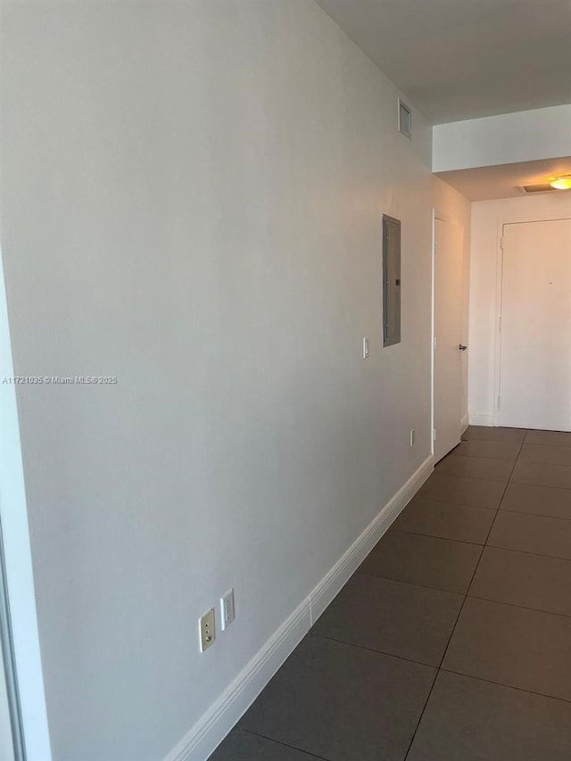 hallway with electric panel and dark tile patterned floors