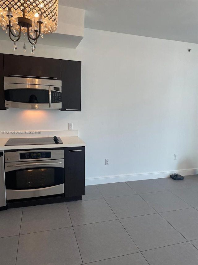 kitchen featuring tile patterned floors, a notable chandelier, and appliances with stainless steel finishes