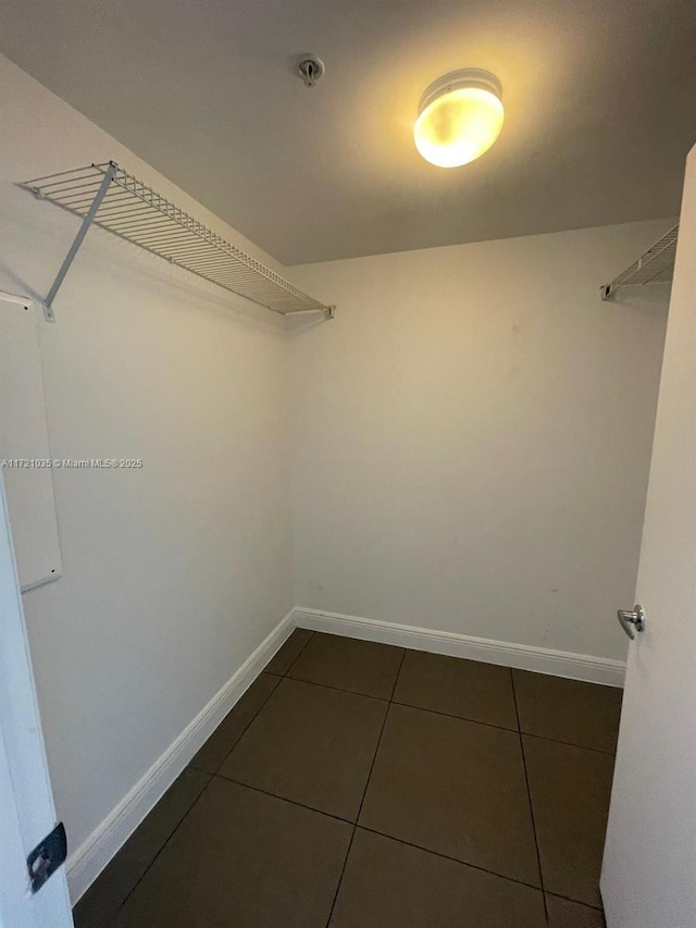 walk in closet featuring dark tile patterned floors