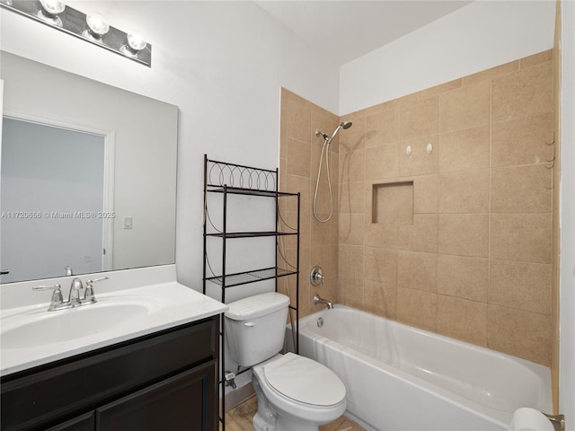 full bathroom featuring vanity, tiled shower / bath combo, and toilet