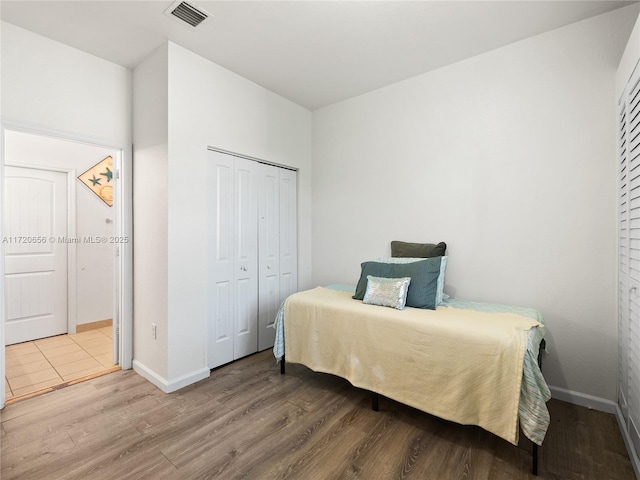 bedroom with hardwood / wood-style floors and a closet