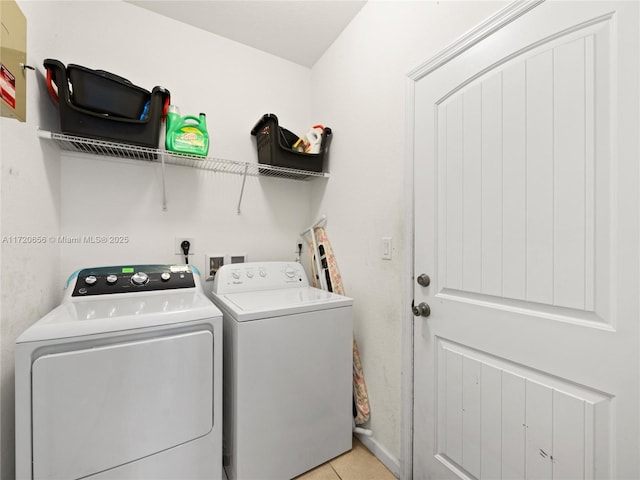 clothes washing area with light tile patterned floors and washer and dryer