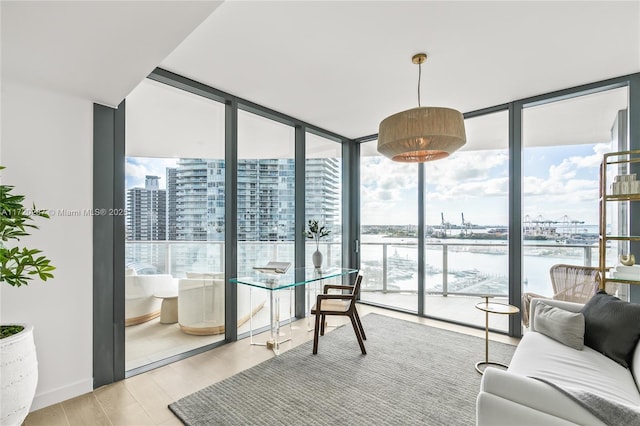 living room with light wood-type flooring, a water view, and expansive windows