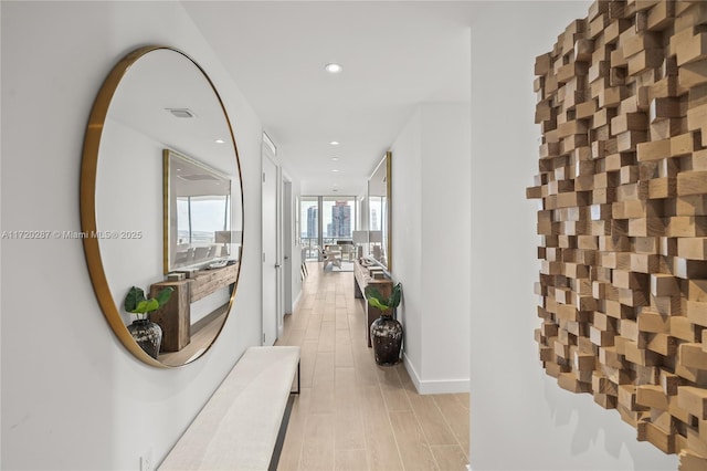 hall featuring floor to ceiling windows and light hardwood / wood-style flooring