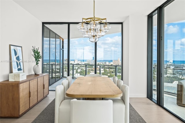 dining space featuring floor to ceiling windows, a notable chandelier, and light hardwood / wood-style floors