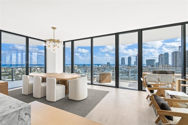 dining area featuring a wall of windows, a chandelier, and hardwood / wood-style floors