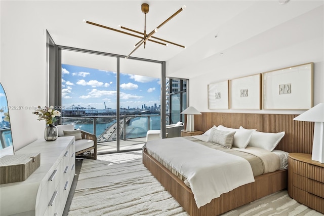 bedroom featuring floor to ceiling windows, multiple windows, access to exterior, and a water view