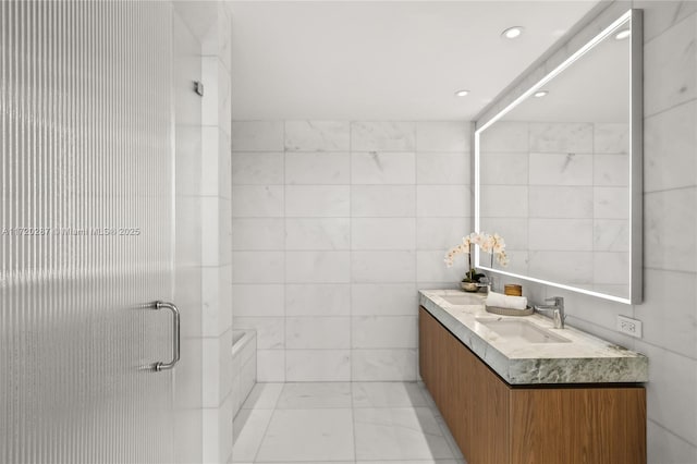 bathroom featuring tile walls, an enclosed shower, and vanity