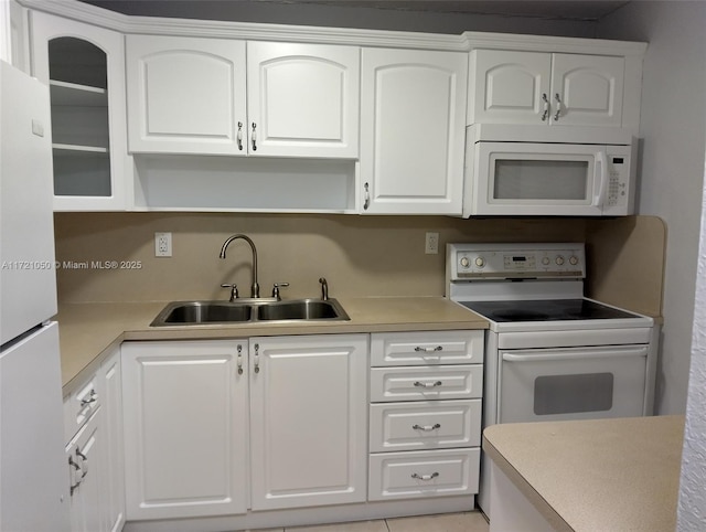 kitchen with white cabinetry, white appliances, and sink