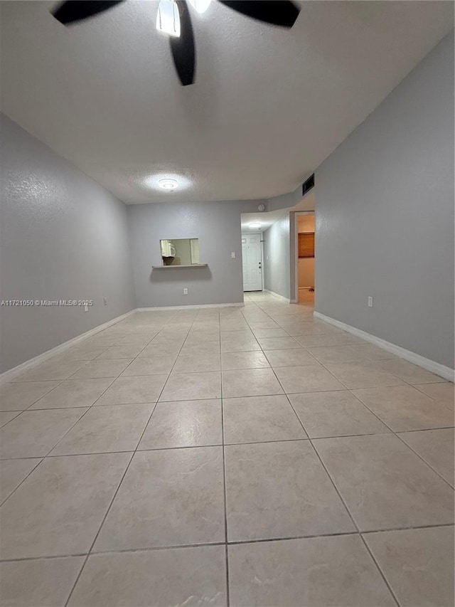 unfurnished room featuring ceiling fan and light tile patterned floors