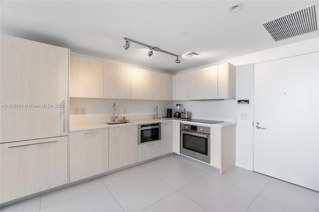 kitchen with light tile patterned floors, black electric cooktop, oven, and sink