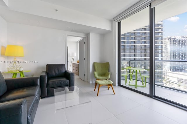 living room featuring a wall of windows and light tile patterned floors