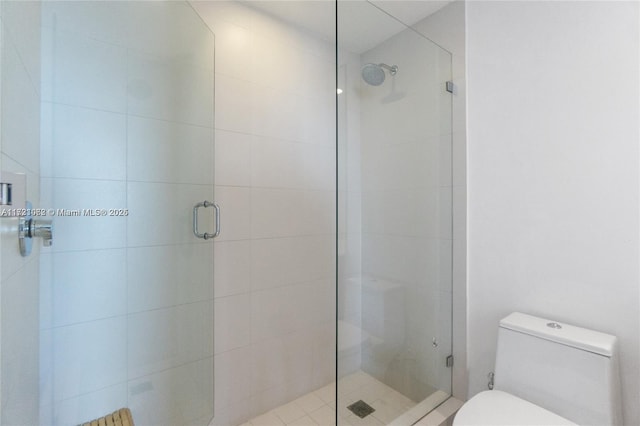 bathroom with toilet and an enclosed shower