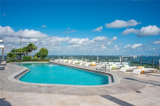 view of swimming pool featuring a water view and a patio area