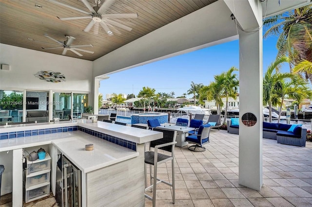 view of patio with exterior bar, an outdoor hangout area, beverage cooler, and ceiling fan