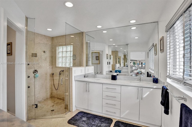 bathroom featuring a shower with door and vanity