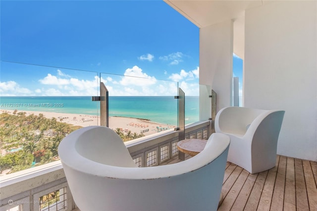 balcony featuring a beach view and a water view