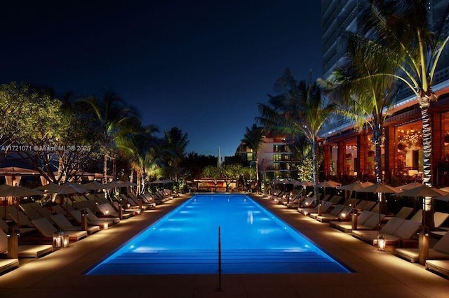 view of pool at twilight