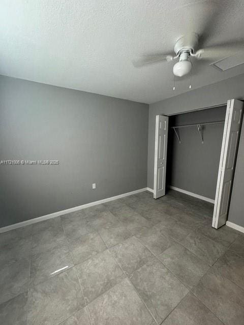 unfurnished bedroom with ceiling fan and a closet