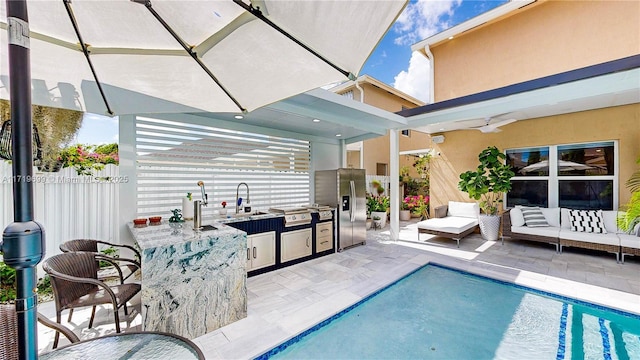 view of swimming pool featuring a patio, area for grilling, a wet bar, ceiling fan, and an outdoor living space