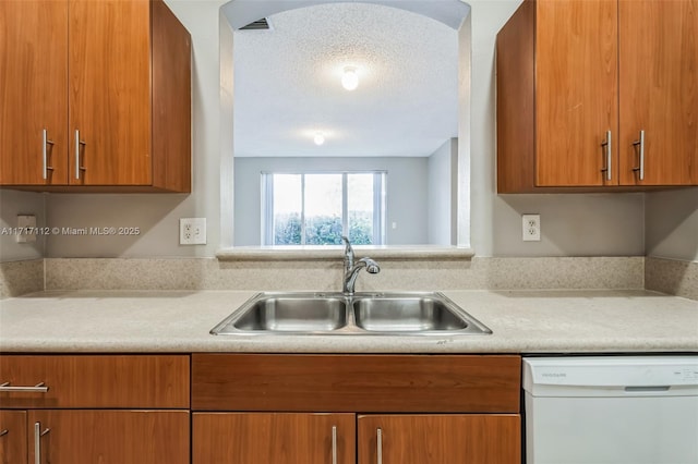 kitchen featuring a textured ceiling, dishwasher, and sink