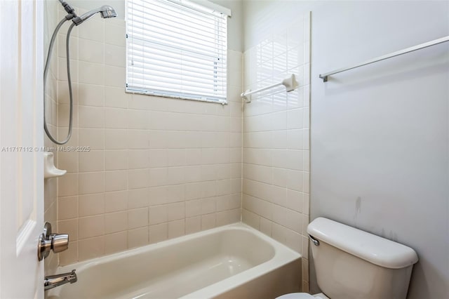 bathroom featuring toilet and tiled shower / bath