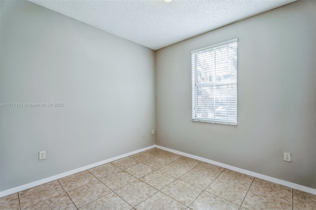 tiled empty room with a textured ceiling