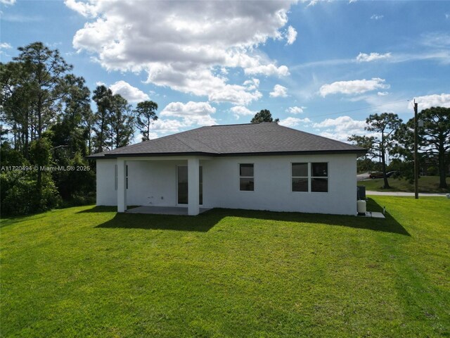 rear view of house featuring a yard and a patio area