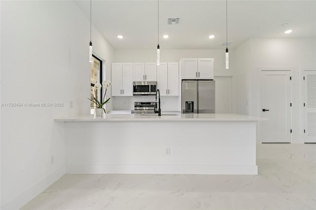 kitchen featuring pendant lighting, sink, appliances with stainless steel finishes, a healthy amount of sunlight, and white cabinetry