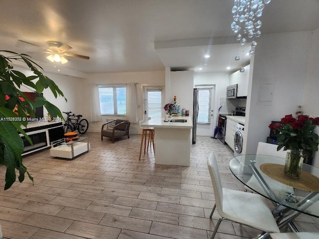 dining area with ceiling fan, sink, and washer / dryer