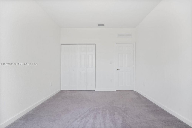 unfurnished bedroom with light carpet and a closet