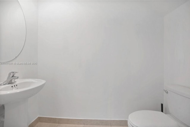 bathroom with tile patterned flooring, toilet, and sink