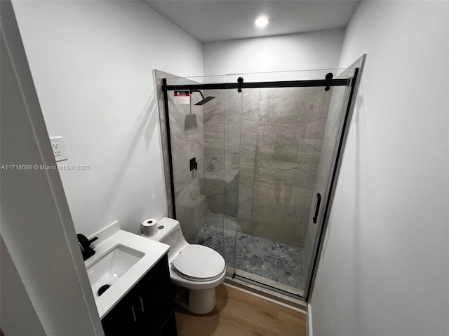 bathroom featuring hardwood / wood-style floors, vanity, an enclosed shower, and toilet